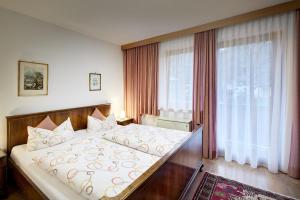 a bedroom with a large bed in front of a window at Appart Burgwies ink Nationalpark Sommercard in Stuhlfelden