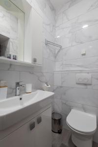 biała łazienka z umywalką i toaletą w obiekcie Villa Elixir w Dubrowniku