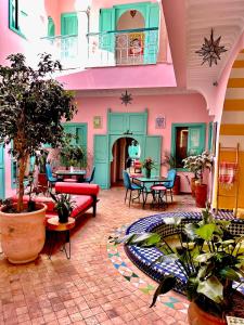 una sala de estar con muebles y plantas de colores. en Riad Lauriers Blancs, en Marrakech