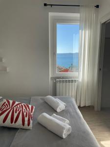 um quarto com uma cama com duas almofadas e uma janela em Il Sogno del Lago em Anguillara Sabazia