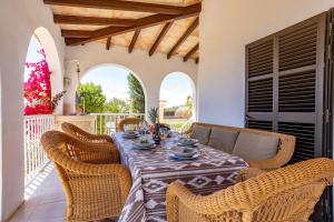 a dining room with a table and wicker chairs at Chalet Irene, mit Pool und Wifi in Santanyi