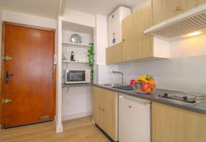 Una cocina con fregadero y puerta de madera. en Le Gallieni By ApiRent #Centre-ville #Lumineux #Wifi, en Cannes