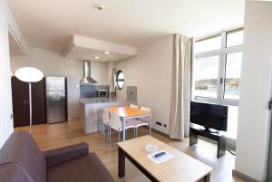 a living room with a couch and a table at Apartamentos Maritimo Ris con garaje in Noja