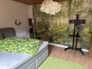 ein Schlafzimmer mit einem Bett und einem Waldbild in der Unterkunft Galeriehaus in Münnerstadt