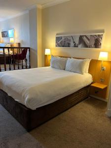 duże łóżko w pokoju hotelowym z 2 lampami w obiekcie Britannia Hotel City Centre Manchester w Manchesterze