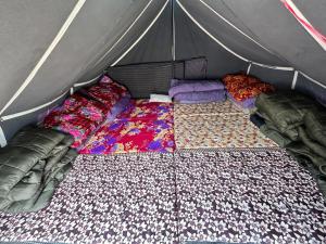 łóżko w namiocie z kocami i poduszkami w obiekcie Kedar Tent House w mieście Kedārnāth