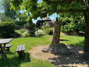 a statue of a giraffe sitting under a tree at Domek wakacyjny nr 2 in Giżycko +8 photos
