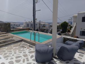 a swimming pool with two lounge chairs next to a house at Fabrica Sunset Apartments in Megali Ammos