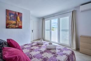a bedroom with a bed and a large window at Villa Cala Dor in Santanyi