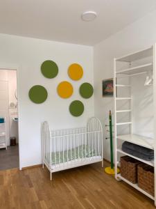 Ebelsberger Terrassen في لينز: حضانة أطفال مع سرير أطفال ودوائر خضراء وصفراء على الحائط