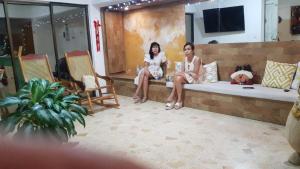 two women sitting on a couch in a room at Hotel CastilloMar in Cartagena de Indias