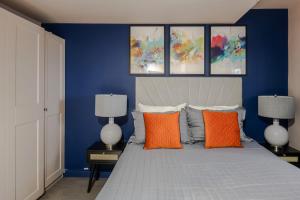 ロンドンにあるUrban Joy - Holborn By Frankie Saysのベッドルーム1室(青い壁のベッド1台、オレンジ色の枕付)
