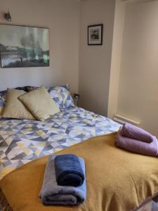 uma cama com duas toalhas em cima em The Potting Shed Sopley em Christchurch