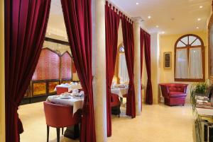 a restaurant with two tables and red curtains at Hotel Ai Due Principi in Venice