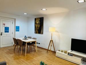 a living room with a table and a tv at Travel Habitat - Centro in Valencia