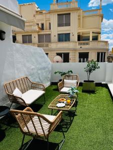 un patio con sillas, una mesa y un edificio en Travel Habitat - Centro, en Valencia