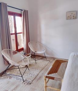 2 weiße Stühle in einem Zimmer mit Fenster in der Unterkunft Zagora Oasis Lodge in Zagora