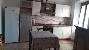 uma cozinha com uma mesa e um frigorífico branco em Antichi Sapori da Speranza em Gavoi