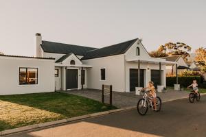 twee mensen die fietsen voor een huis bij Robertson Halfway House in Robertson