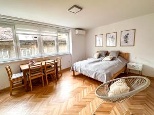 ein Schlafzimmer mit einem Bett und einem Tisch und Stühlen in der Unterkunft Cheyf Modern Studio in Center in Sarajevo