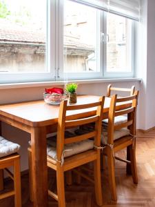 einen Esstisch und Stühle mit Fenster in der Unterkunft Cheyf Modern Studio in Center in Sarajevo