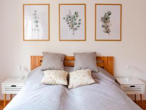 ein Schlafzimmer mit einem Bett mit drei Bildern an der Wand in der Unterkunft Cheyf Modern Studio in Center in Sarajevo