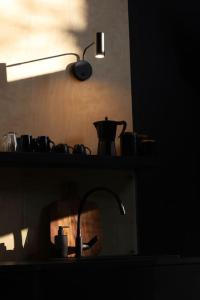 a kitchen with a sink and a lamp on a shelf at Domek SzumiSosna1 in Raków