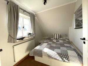 1 dormitorio con 1 cama con manta a cuadros en Wohnung-Inseloase, en Westerland