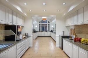 uma grande cozinha com armários brancos e piso em azulejo em Residence Inn Sandestin at Grand Boulevard em Destin