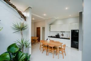 a kitchen and dining room with a wooden table and chairs at Kubu Gena Guesthouse Canggu in Canggu