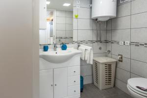 a white bathroom with a sink and a toilet at Apartments Storia in Trogir +30 photos