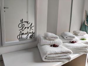 ein Haufen Handtücher, die auf einem Regal vor einem Spiegel liegen in der Unterkunft Bologna Travel Suite in Bologna