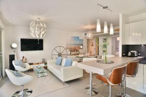 a living room with a white couch and a table at Appartement de rêve avec terrasse et garage in Cannes