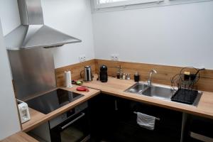 eine Küche mit Spüle und Arbeitsplatte in der Unterkunft Maison charmante et spacieuse-terrasse près du centre ville in Amiens