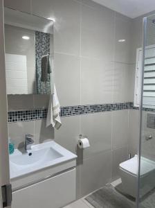 a white bathroom with a sink and a toilet at Serene living in East London