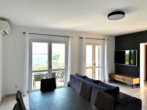 a living room with a couch and a table with a television at Résidence Aigue Marine in Coti-Chiavari