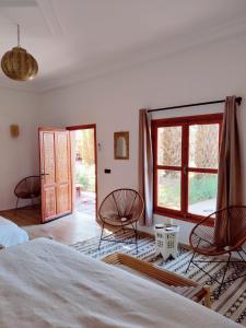 1 dormitorio con 2 sillas y una ventana grande en Zagora Oasis Lodge en Zagora