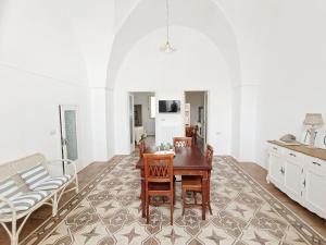 a dining room with a table and chairs and a couch at Domus Donata in Galatone