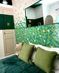 a bedroom with a mirror and a bed with green pillows at Riad Lauriers Blancs in Marrakesh