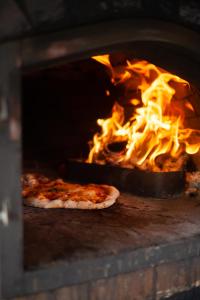 two pizzas are cooking in a brick oven at Hoot in Abergele