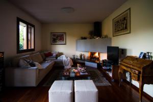 ein Wohnzimmer mit einem Sofa und einem Kamin in der Unterkunft Al Parco Storga B&b in Treviso