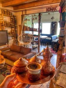 Konak Umoljani في Umoljani: غرفة معيشة مع طاولة عليها مزهريات