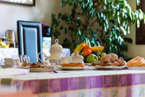 einen Tisch mit Teller mit Lebensmitteln und Obst in der Unterkunft Al Parco Storga B&b in Treviso