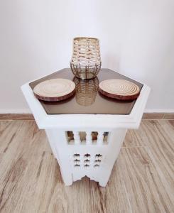 una mesa blanca con platos y un jarrón en ella en Zagora Oasis Lodge, en Zagora