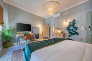 a bedroom with a bed and a desk and a television at Maison Medina Malta in Mdina