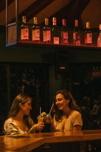 two women sitting at a bar with a drink at Soy Local Guatape in Guatapé