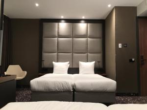 a bedroom with two beds and a large headboard at Hotel Levell in Amsterdam