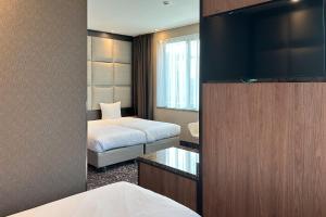 Habitación de hotel con cama y TV en Hotel Levell en Ámsterdam