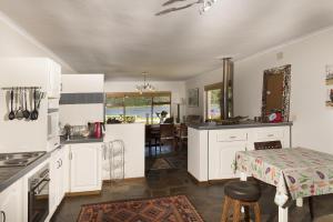 a kitchen with white cabinets and a table and a dining room at Estuary Breeze in Sedgefield