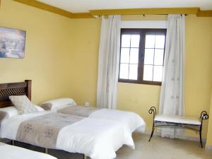 een slaapkamer met 3 bedden en een raam bij 4 bedrooms house with furnished terrace at Yegen in Yegen